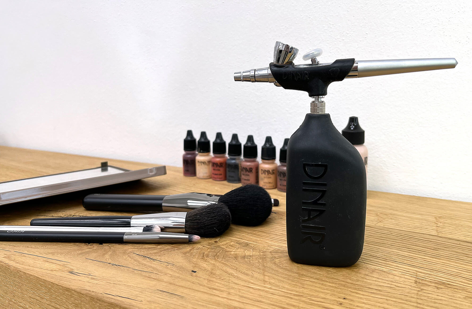 An airbrush with makeup brushes.
